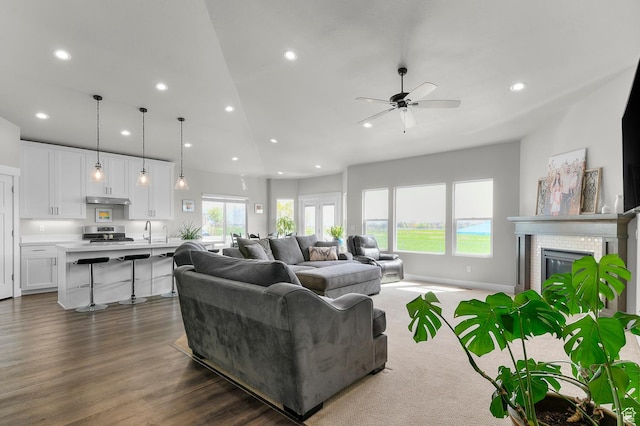 living room with recessed lighting, dark wood-type flooring, a fireplace, and ceiling fan