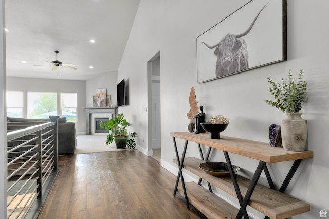 corridor with baseboards, recessed lighting, and wood finished floors