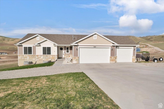 view of front of home with an attached garage, stone siding, board and batten siding, a front lawn, and driveway