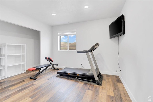 exercise room featuring baseboards, recessed lighting, and wood finished floors