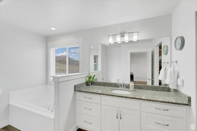 bathroom featuring vanity and a garden tub