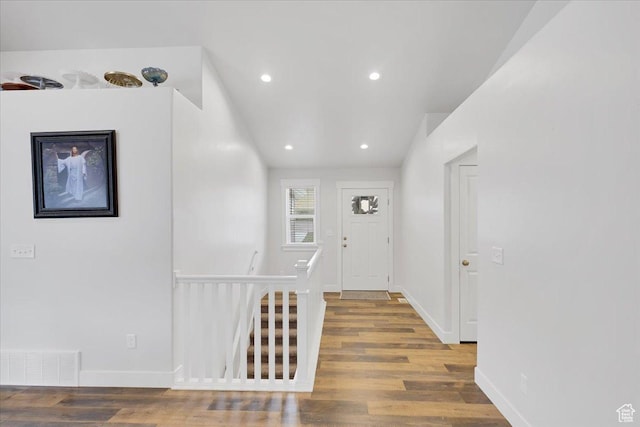 hall with visible vents, recessed lighting, wood finished floors, an upstairs landing, and baseboards