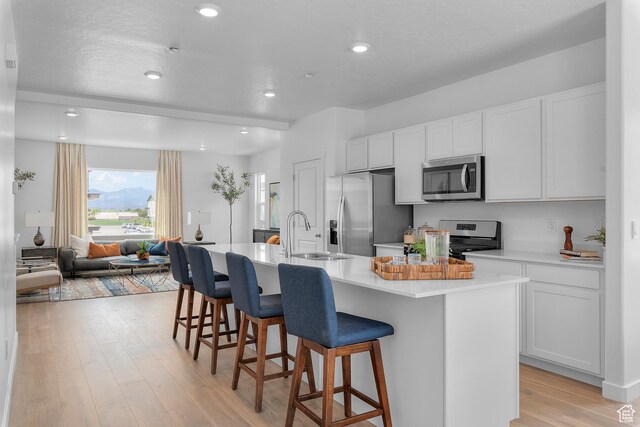 419 S 1130 W Unit 208, American Fork, UT 84003 - kitchen with appliances with stainless steel finishes, a kitchen island with sink, a sink, and a breakfast bar