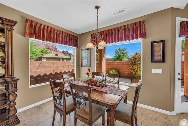 dining space featuring light tile patterned floors, visible vents, baseboards, and an inviting chandelier