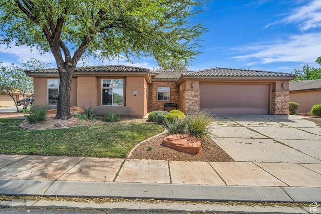 ranch-style home with an attached garage, stucco siding, stone siding, and a tile roof