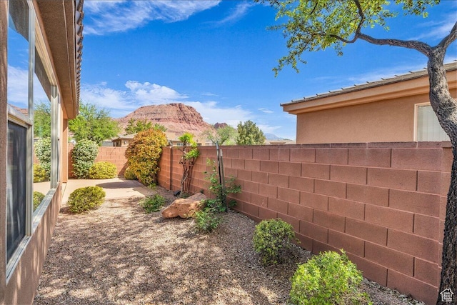view of yard featuring a mountain view and a fenced backyard