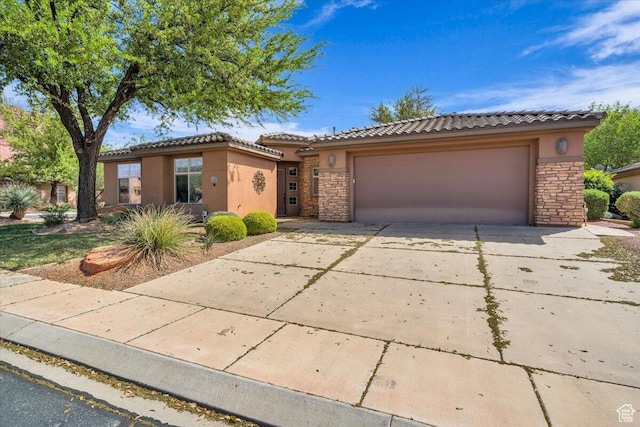 ranch-style home with a tiled roof, driveway, stucco siding, and stone siding
