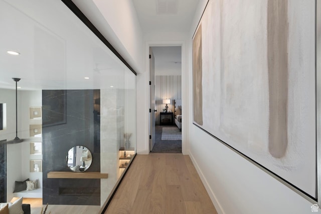 hallway with recessed lighting, visible vents, light wood-type flooring, and baseboards