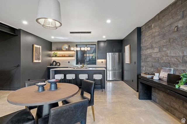 dining room with recessed lighting, finished concrete flooring, and baseboards