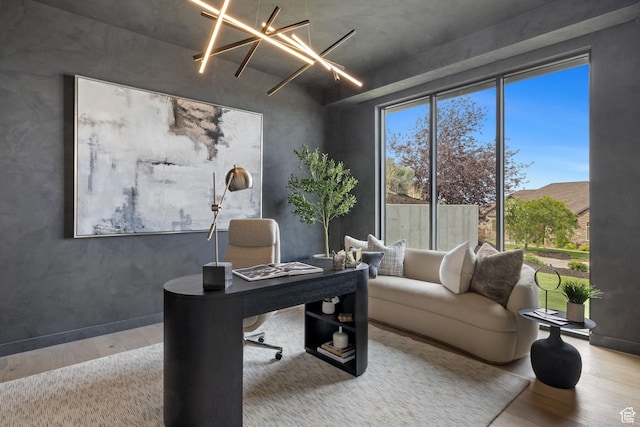 office with wood finished floors and an inviting chandelier