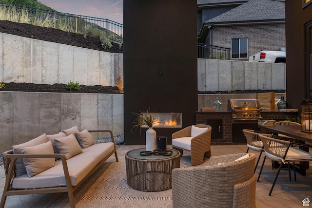 view of patio featuring an outdoor living space with a fireplace, fence, exterior kitchen, and area for grilling