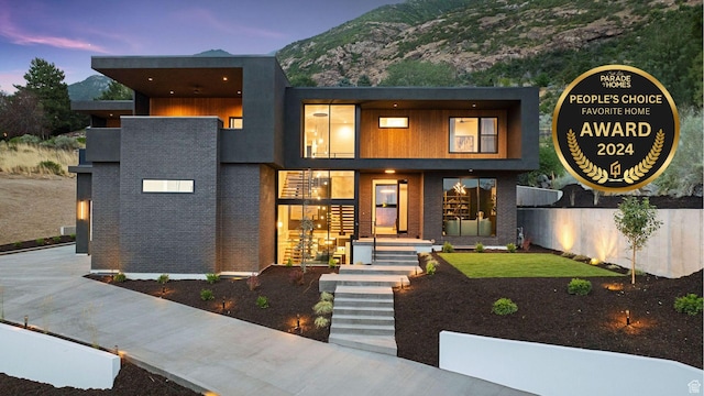 modern home with a mountain view and brick siding