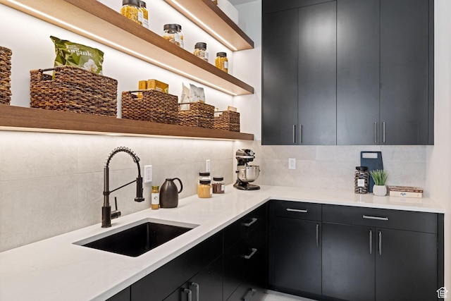 kitchen with a sink, open shelves, and dark cabinets