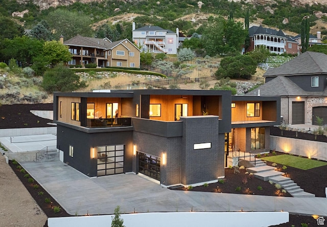 view of front of property with an attached garage, driveway, a residential view, and a balcony