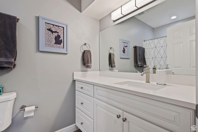 full bath with a shower with shower curtain, vanity, baseboards, recessed lighting, and toilet