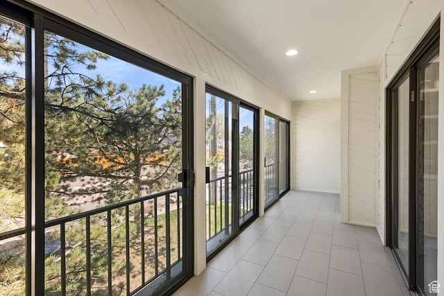unfurnished sunroom featuring wooden walls, recessed lighting, and tile patterned flooring