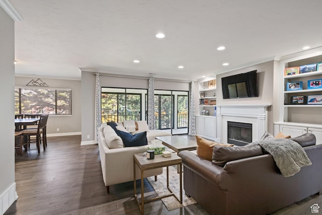 living room featuring baseboards, ornamental molding, recessed lighting, a fireplace, and dark wood-type flooring