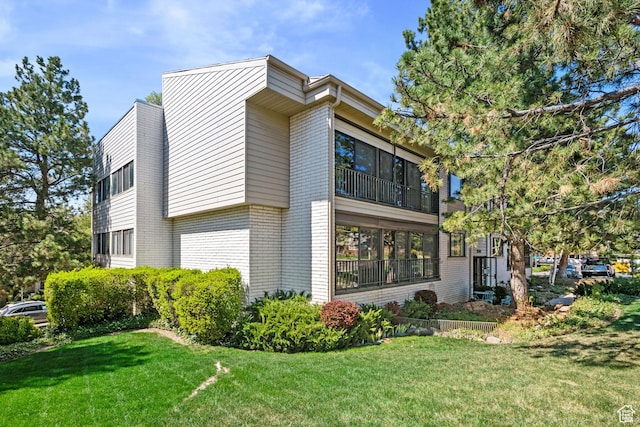view of home's exterior with a yard and brick siding