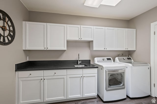 clothes washing area with a sink, cabinet space, and washing machine and dryer