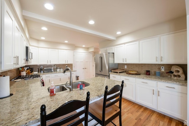 1960 S High Pointe St E Unit 22, Bountiful, UT 84010 - kitchen with a kitchen breakfast bar, a peninsula, backsplash, appliances with stainless steel finishes, and a sink