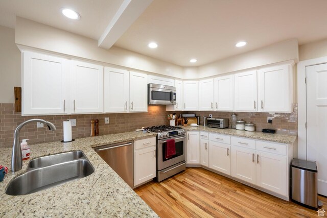 1960 S High Pointe St E Unit 22, Bountiful, UT 84010 - kitchen with white cabinets, tasteful backsplash, a sink, and appliances with stainless steel finishes