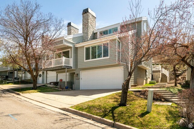 1960 S High Pointe St E Unit 22, Bountiful, UT 84010 - view of front of property with driveway, stairway, a garage, and a chimney