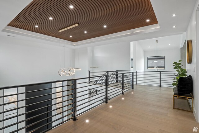 1582 S Wiltshire Ln, Saratoga Springs, UT 84045 - hallway featuring a notable chandelier, an upstairs landing, a tray ceiling, recessed lighting, and wood finished floors