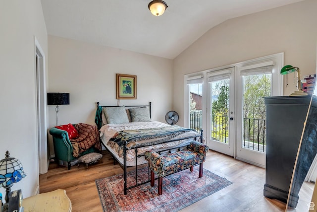 bedroom featuring access to outside, light wood-style floors, and lofted ceiling