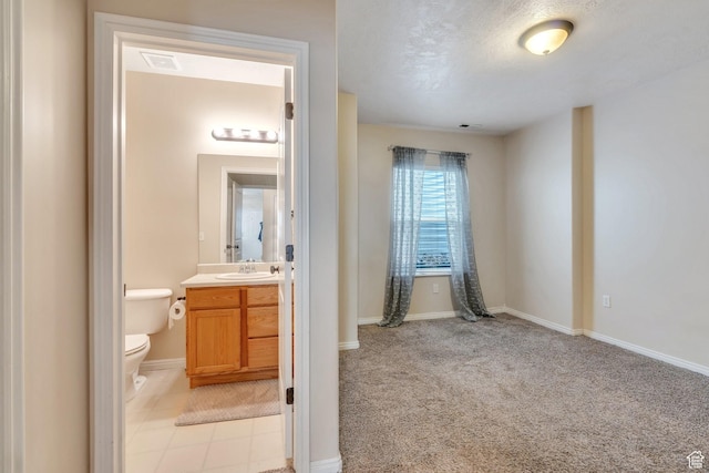 half bath featuring vanity, baseboards, visible vents, and toilet