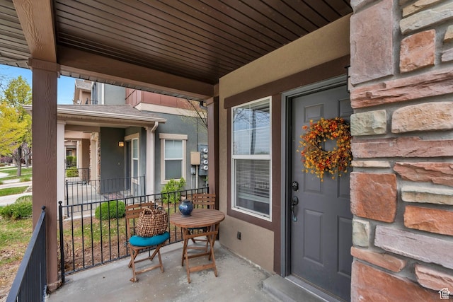 property entrance featuring covered porch and stucco siding