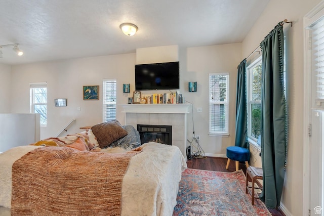 living area with a fireplace, baseboards, and wood finished floors