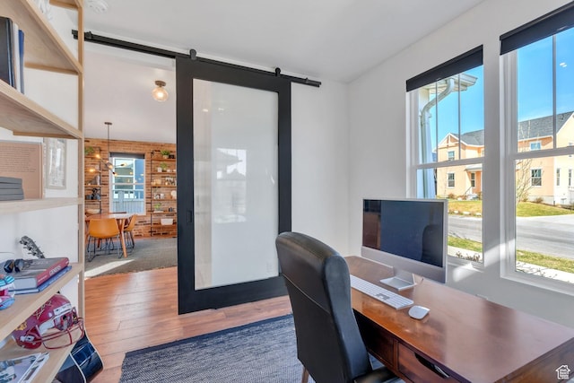 office area with wood finished floors and a barn door