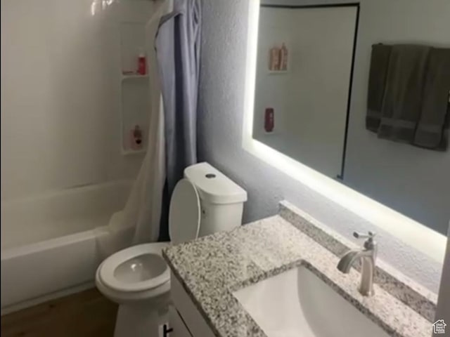 full bathroom featuring toilet, shower / bath combo, and vanity