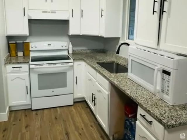 kitchen featuring white appliances, white cabinetry, extractor fan, dark wood finished floors, and a sink