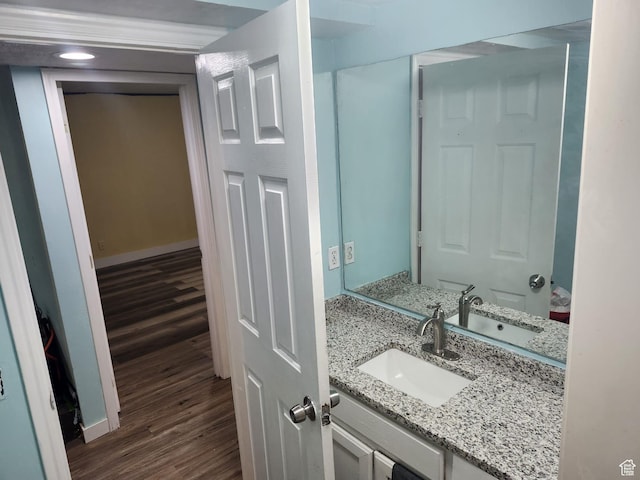 bathroom featuring wood finished floors, vanity, and baseboards