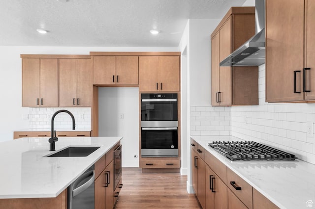 1489 E 820 N Unit 104, Salem, UT 84653 - kitchen featuring wall chimney exhaust hood, stainless steel appliances, light stone counters, backsplash, and wood finished floors