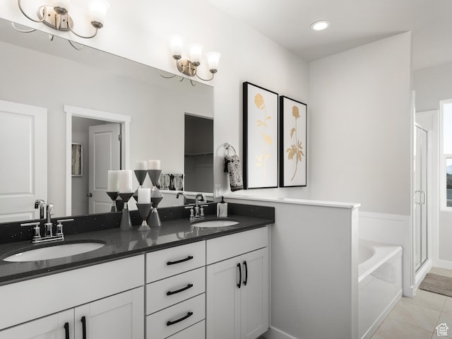 full bathroom featuring a stall shower, a garden tub, double vanity, and a sink