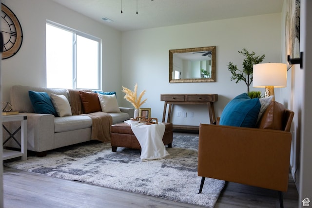 living area featuring visible vents and wood finished floors