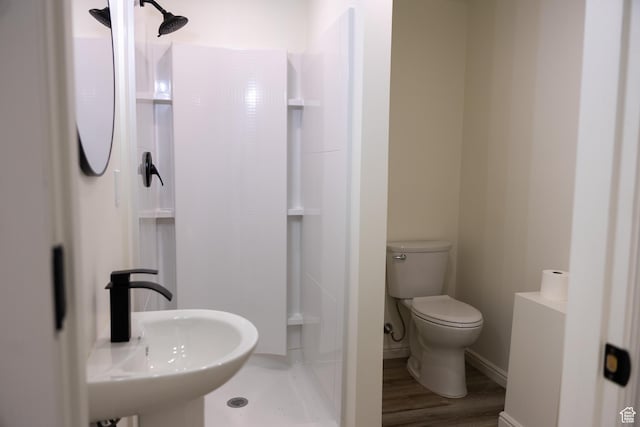 full bath with a shower, a sink, toilet, and wood finished floors