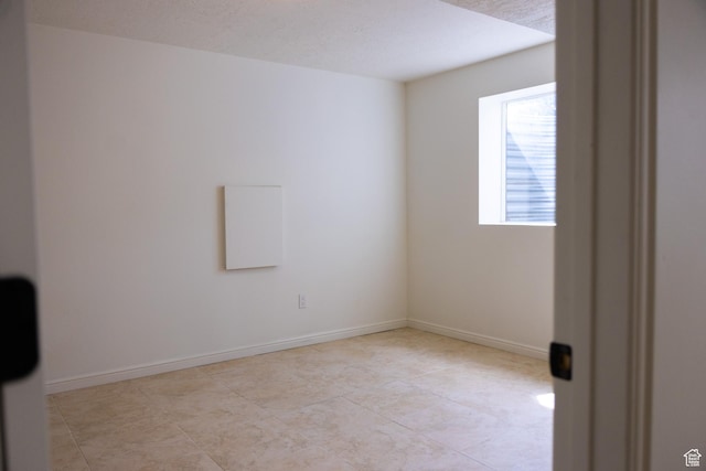 unfurnished room featuring baseboards