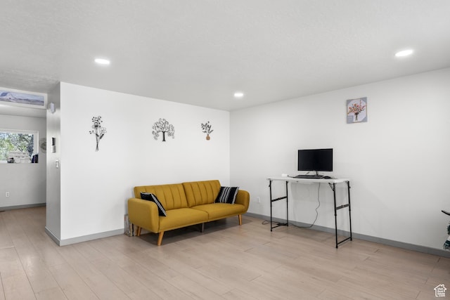 living area featuring recessed lighting, baseboards, and wood finished floors