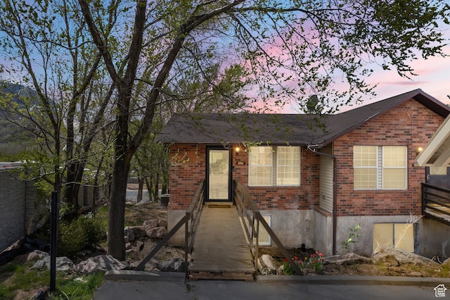 single story home with brick siding, fence, and a shingled roof