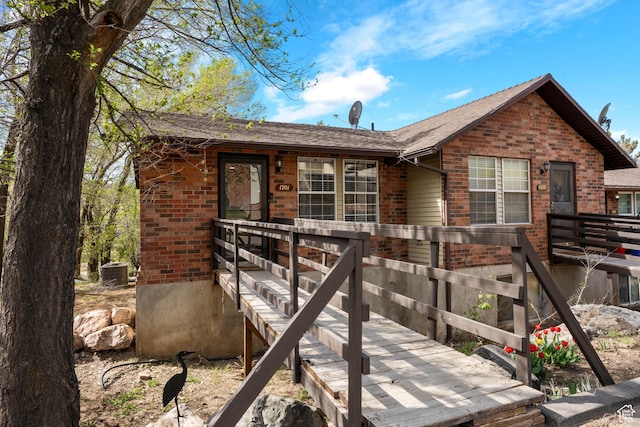 view of front of property with brick siding and central AC unit