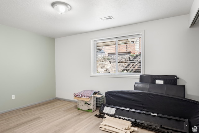 sitting room with light wood-style floors, baseboards, and visible vents