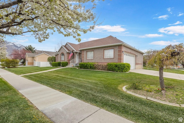 ranch-style home featuring a front yard, an attached garage, fence, brick siding, and driveway