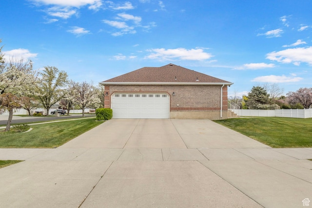 view of side of property featuring an attached garage, a lawn, fence, concrete driveway, and brick siding