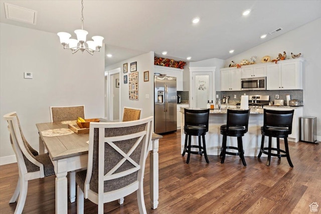 dining room featuring dark wood-style flooring, visible vents, recessed lighting, and a chandelier