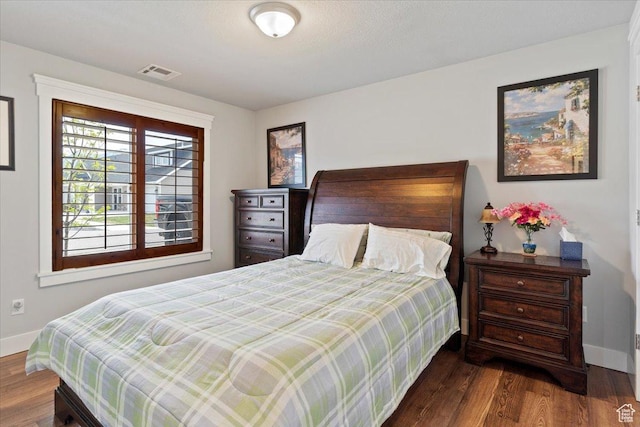 bedroom with wood finished floors, baseboards, and visible vents