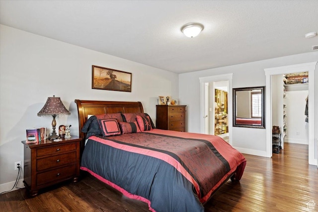 bedroom featuring dark wood-style flooring and baseboards