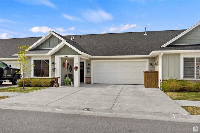 view of front of home featuring roof with shingles, driveway, board and batten siding, and an attached garage